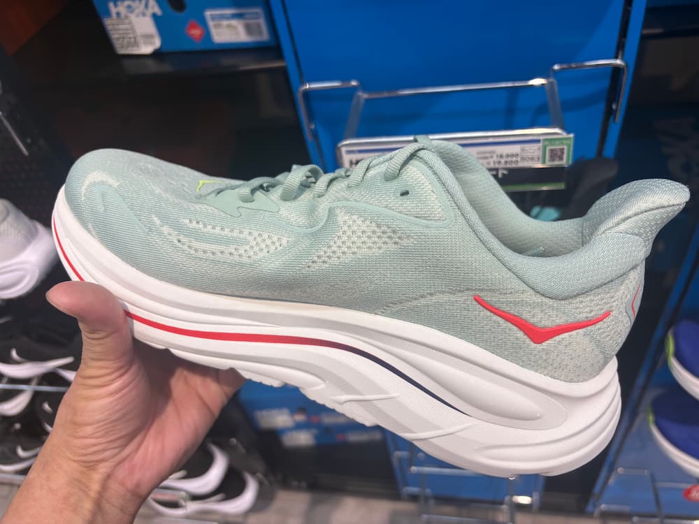 HOKAのクリフトン10を手に持ってる写真