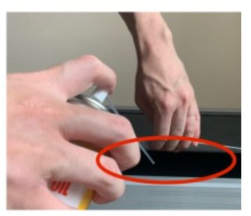 ベルトの間にスプレーを噴射している写真
